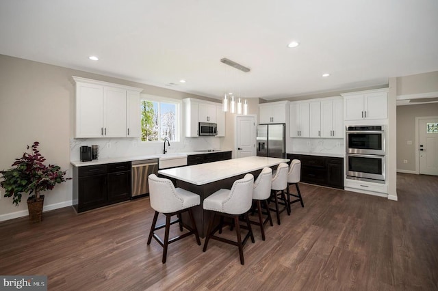 112 Edgehill Dr, Locust Grove, VA 22508 - kitchen featuring stainless steel appliances, a breakfast bar area, white cabinets, dark wood-style flooring, and a center island