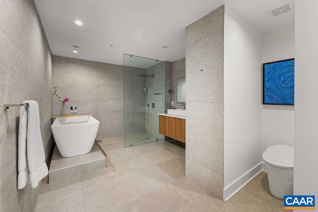 218 Water St W Unit 705, Charlottesville, VA 22902 - bathroom featuring tile walls, walk in shower, visible vents, vanity, and a freestanding bath