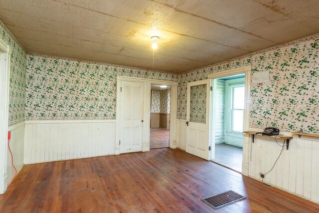 253 Church St, Timberville, VA 22853 - spare room featuring wainscoting, hardwood / wood-style flooring, visible vents, and wallpapered walls
