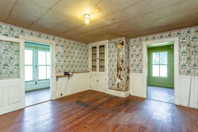 253 Church St, Timberville, VA 22853 - spare room featuring wallpapered walls, dark wood finished floors, visible vents, and wainscoting