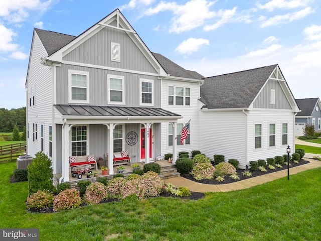 view of front of property featuring roof with shingles, covered porch, a front lawn, and a standing seam roof