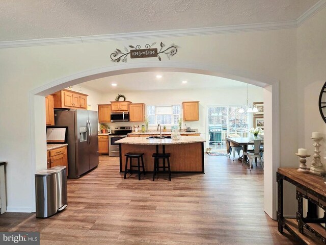 14511 Antler Rd, Fredericksburg, VA 22407 - kitchen with stainless steel appliances, a sink, light wood-style floors, crown molding, and a textured ceiling