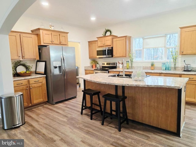 14511 Antler Rd, Fredericksburg, VA 22407 - kitchen with stainless steel appliances, light wood-style flooring, a kitchen island with sink, arched walkways, and a breakfast bar area