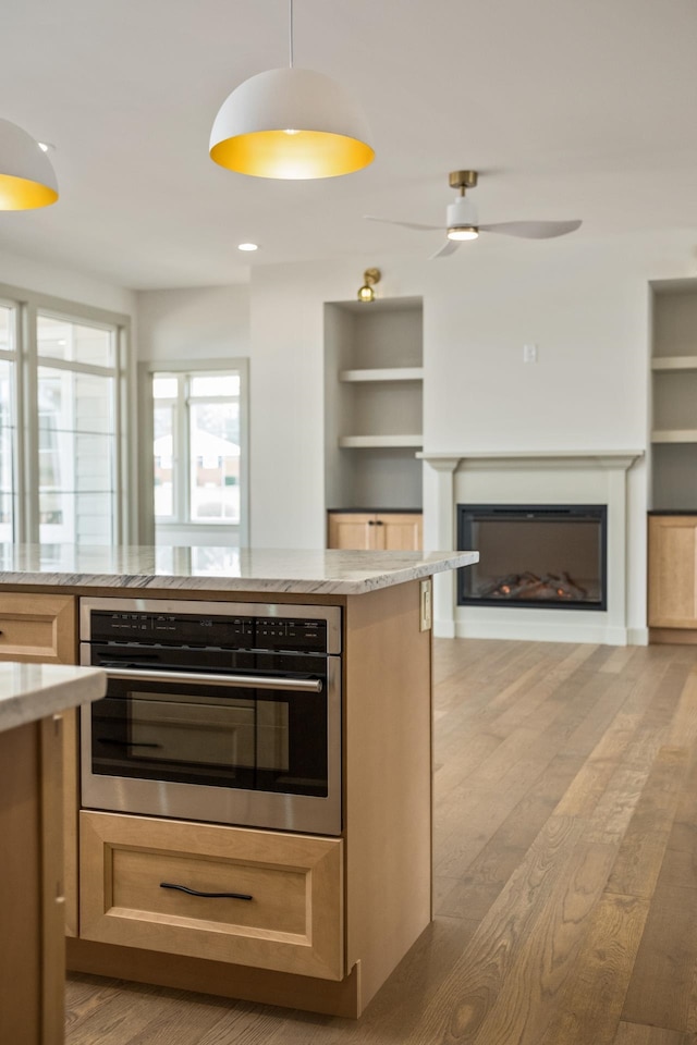135 Radnor Ct, Rockingham, VA 22801 - kitchen featuring open floor plan, light wood-type flooring, built in features, light stone countertops, and a glass covered fireplace
