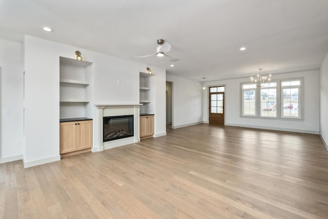 135 Radnor Ct, Rockingham, VA 22801 - unfurnished living room with light wood-style flooring, baseboards, a glass covered fireplace, ceiling fan with notable chandelier, and built in shelves