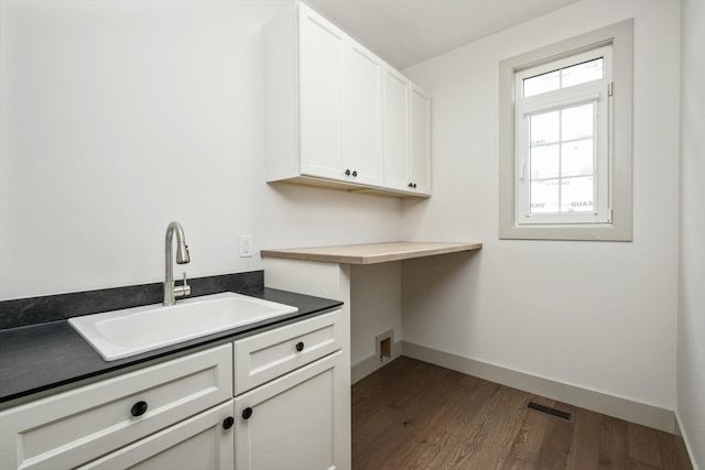 135 Radnor Ct, Rockingham, VA 22801 - laundry area with baseboards, dark wood-style flooring, visible vents, a sink, and cabinet space