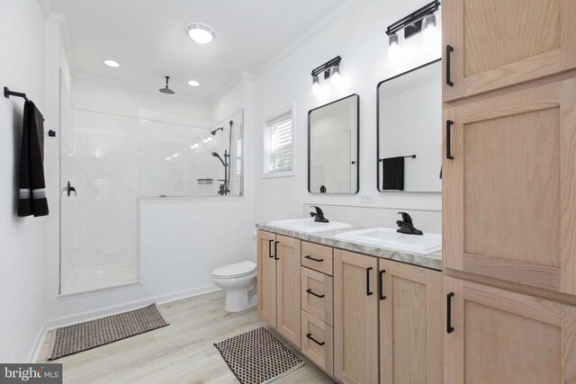 full bathroom featuring a sink, walk in shower, crown molding, and double vanity