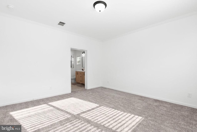 unfurnished bedroom with visible vents, light carpet, baseboards, and crown molding