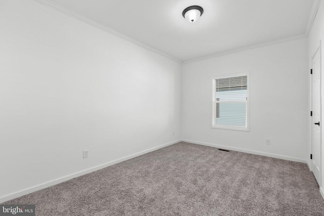 carpeted spare room featuring visible vents, baseboards, and ornamental molding