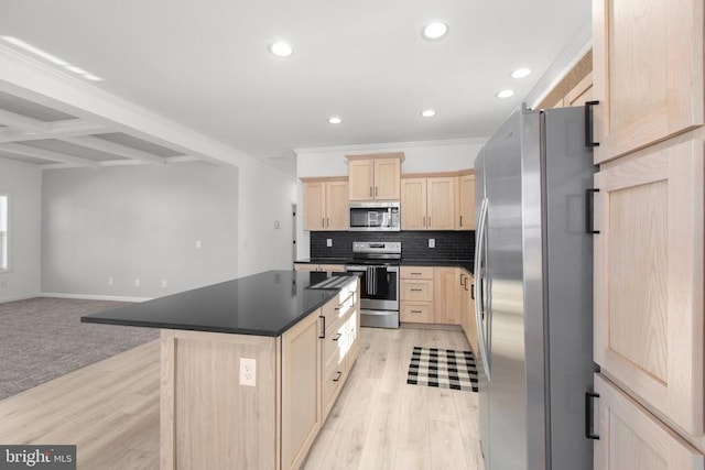 kitchen featuring light brown cabinets, dark countertops, light wood-style floors, appliances with stainless steel finishes, and decorative backsplash