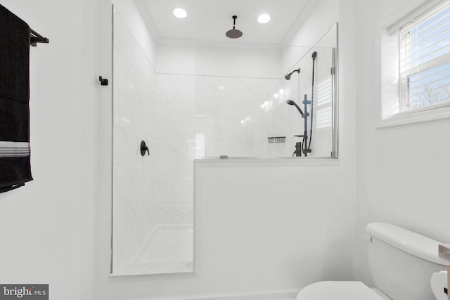 full bathroom with crown molding, toilet, and a tile shower