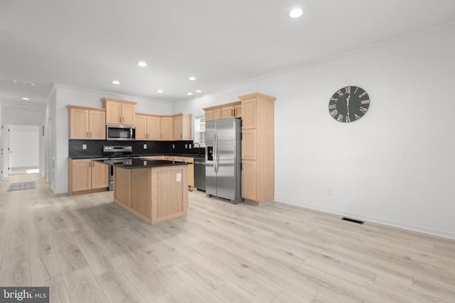 kitchen featuring visible vents, light brown cabinets, backsplash, a center island, and stainless steel appliances