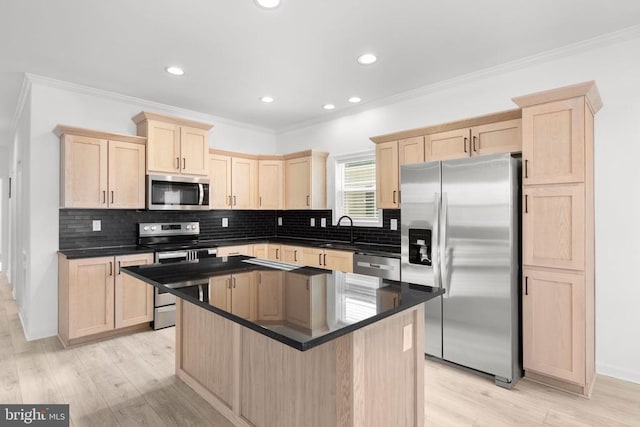 kitchen with a sink, dark countertops, appliances with stainless steel finishes, and light brown cabinets