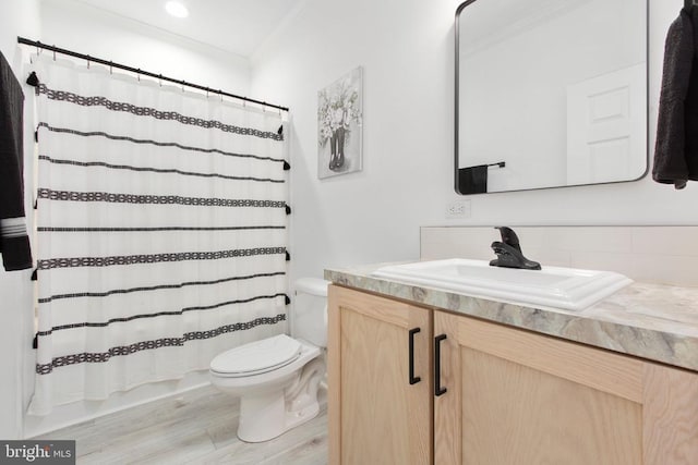 full bathroom featuring toilet, wood finished floors, vanity, and crown molding