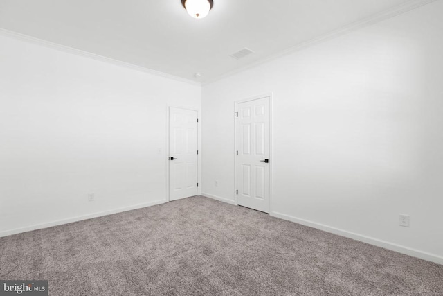 carpeted spare room with visible vents, baseboards, and ornamental molding