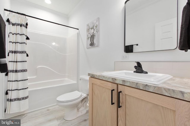 full bath featuring vanity, wood finished floors, shower / tub combo, crown molding, and toilet