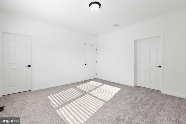 unfurnished bedroom featuring visible vents, baseboards, carpet flooring, and crown molding