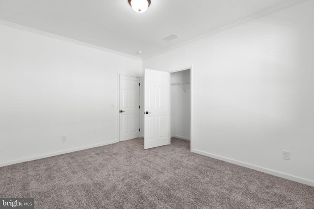 unfurnished bedroom featuring visible vents, crown molding, baseboards, carpet floors, and a closet