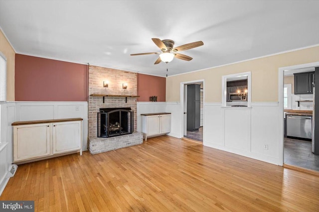 7615 Morris Rd, Spotsylvania, VA 22551 - unfurnished living room featuring ceiling fan, a decorative wall, light wood-style floors, a brick fireplace, and ornamental molding