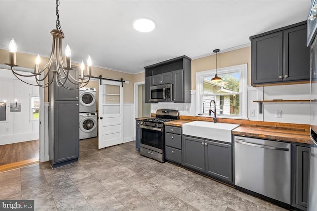7615 Morris Rd, Spotsylvania, VA 22551 - kitchen with stainless steel appliances, butcher block countertops, stacked washer / dryer, a sink, and crown molding