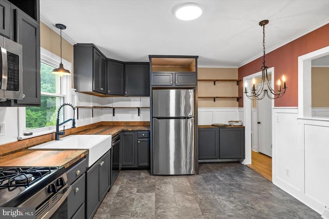 7615 Morris Rd, Spotsylvania, VA 22551 - kitchen with stainless steel appliances, a sink, a chandelier, crown molding, and open shelves