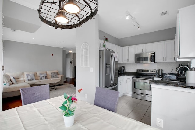 dining area featuring light tile patterned floors, visible vents, and ornamental molding