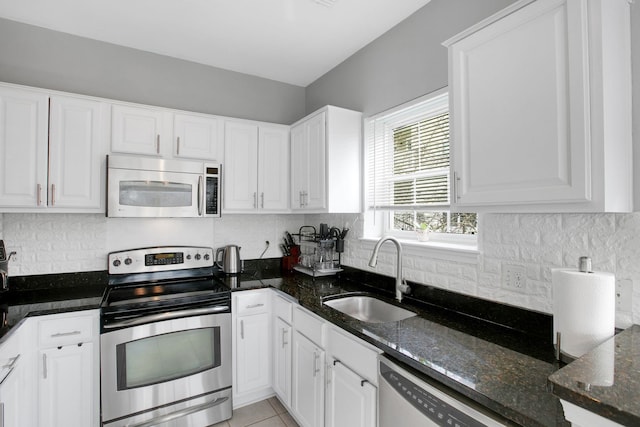 kitchen with decorative backsplash, appliances with stainless steel finishes, white cabinetry, and a sink