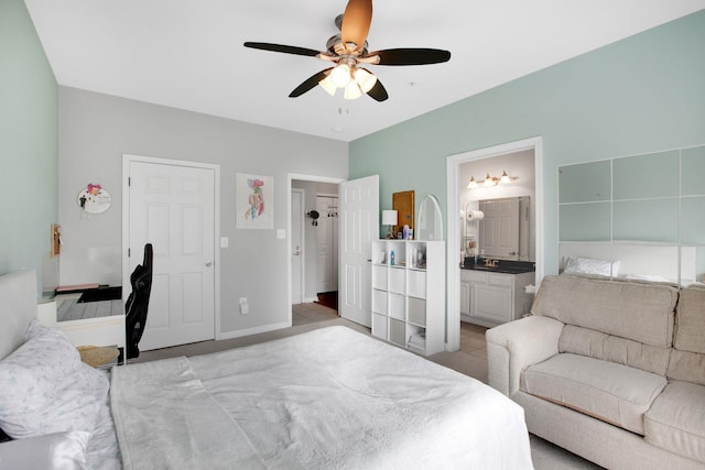 bedroom with light tile patterned floors, connected bathroom, baseboards, and a ceiling fan