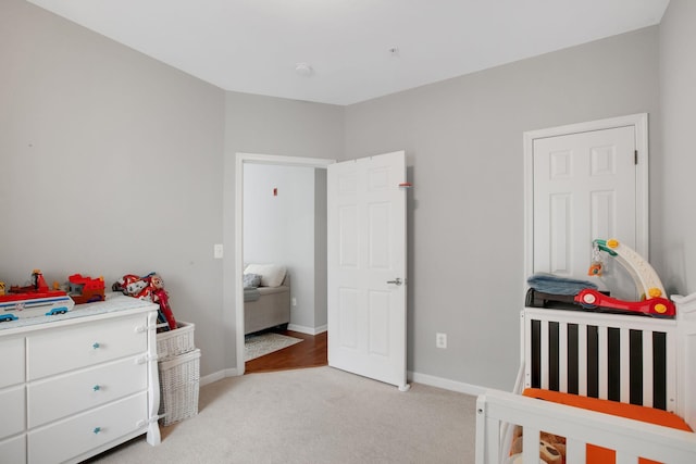 bedroom with light colored carpet and baseboards