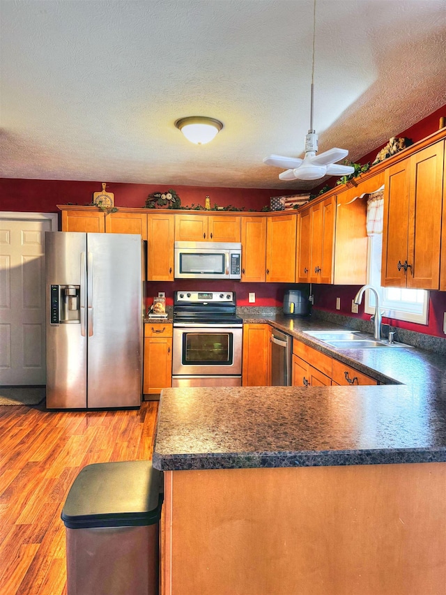 12101 Squirrel Dr, Fulks Run, VA 22830 - kitchen featuring stainless steel appliances, brown cabinets, light wood-style flooring, a peninsula, and a ceiling fan