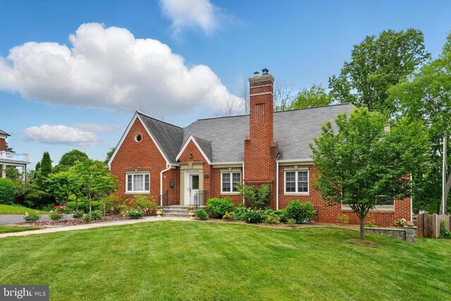 view of front of home with brick siding and a front yard