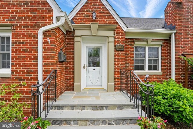 doorway to property featuring brick siding