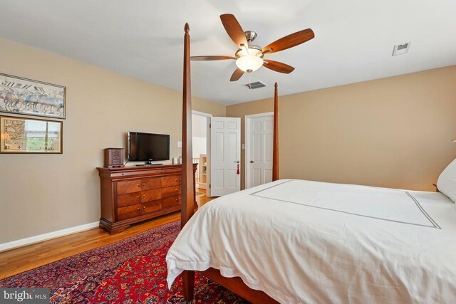 bedroom with wood finished floors, baseboards, and ceiling fan