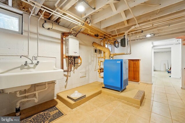 below grade area featuring water heater and light tile patterned flooring