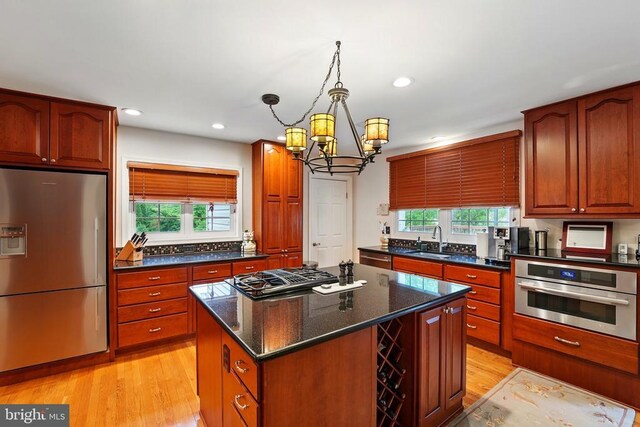 kitchen featuring stainless steel appliances, a sink, healthy amount of natural light, light wood-style flooring, and recessed lighting