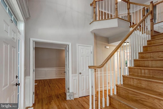 11211 Spring Meadow Blvd, Fredericksburg, VA 22407 - entrance foyer featuring a towering ceiling, stairway, wood finished floors, a decorative wall, and wainscoting