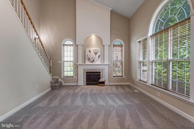 11211 Spring Meadow Blvd, Fredericksburg, VA 22407 - unfurnished living room featuring carpet floors, healthy amount of natural light, a tile fireplace, and a towering ceiling
