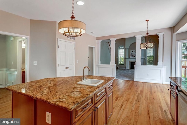 11211 Spring Meadow Blvd, Fredericksburg, VA 22407 - kitchen featuring a decorative wall, a fireplace, light wood-type flooring, brown cabinetry, and plenty of natural light