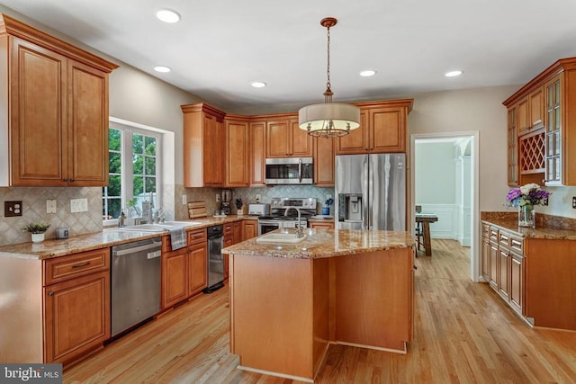 11211 Spring Meadow Blvd, Fredericksburg, VA 22407 - kitchen with stainless steel appliances, light stone counters, light wood-type flooring, recessed lighting, and wainscoting