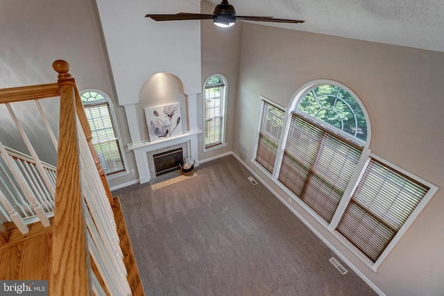 11211 Spring Meadow Blvd, Fredericksburg, VA 22407 - unfurnished living room with carpet flooring, ceiling fan, a towering ceiling, and a tile fireplace