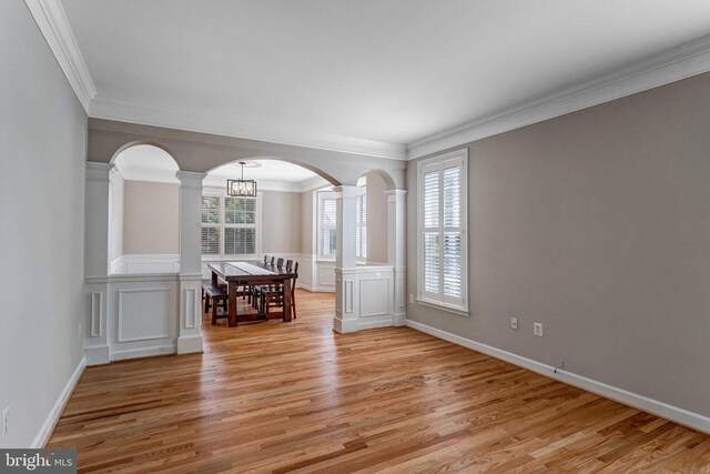 11211 Spring Meadow Blvd, Fredericksburg, VA 22407 - spare room featuring light wood-style floors, decorative columns, crown molding, arched walkways, and a chandelier