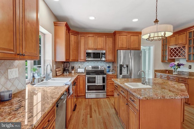 11211 Spring Meadow Blvd, Fredericksburg, VA 22407 - kitchen with stainless steel appliances, light wood-style floors, brown cabinetry, light stone countertops, and recessed lighting