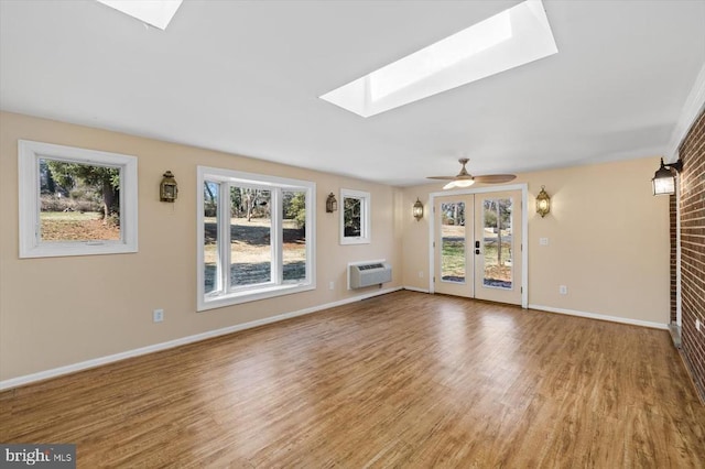 148 Red Hill Rd, Orange, VA 22960 - unfurnished living room featuring a skylight, wood finished floors, baseboards, and a wall unit AC