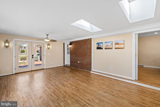 148 Red Hill Rd, Orange, VA 22960 - unfurnished living room featuring a skylight, wood finished floors, baseboards, french doors, and a ceiling fan