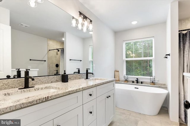 5509 Bazzanella Dr, Mineral, VA 23117 - bathroom featuring a stall shower, double vanity, a freestanding tub, and recessed lighting
