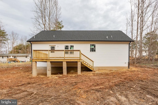 rear view of house featuring a deck, roof with shingles, and stairs