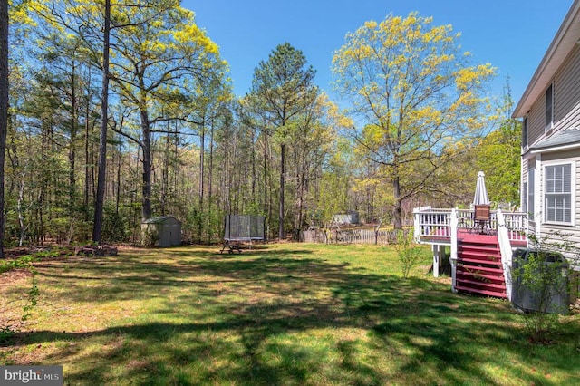 8802 Dundee Dr, Fredericksburg, VA 22408 - view of green lawn featuring a storage shed, a wooden deck, an outdoor structure, a trampoline, and stairway