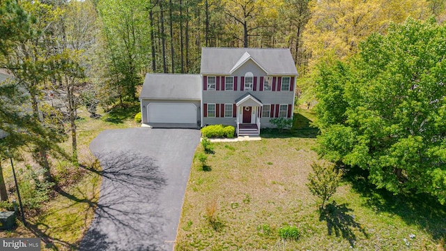 8802 Dundee Dr, Fredericksburg, VA 22408 - colonial inspired home with an attached garage, driveway, a wooded view, a porch, and a front yard