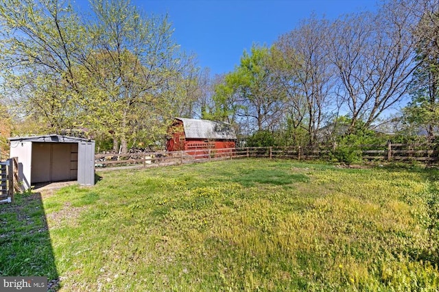 view of yard featuring an outbuilding, a storage unit, and a barn