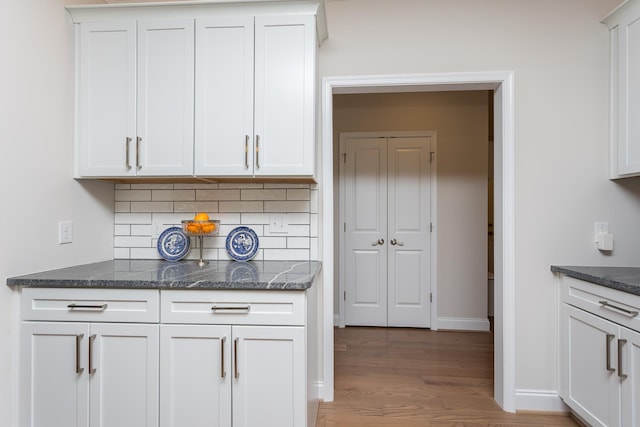 33 Silver Maple Cv, Fishersville, VA 22939 - kitchen featuring decorative backsplash, wood finished floors, dark stone counters, white cabinetry, and baseboards